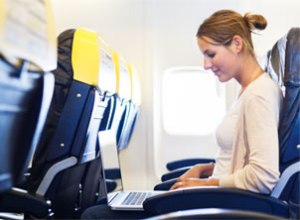Young_Woman_Working_on_Laptop_on_Plane_Horizontal